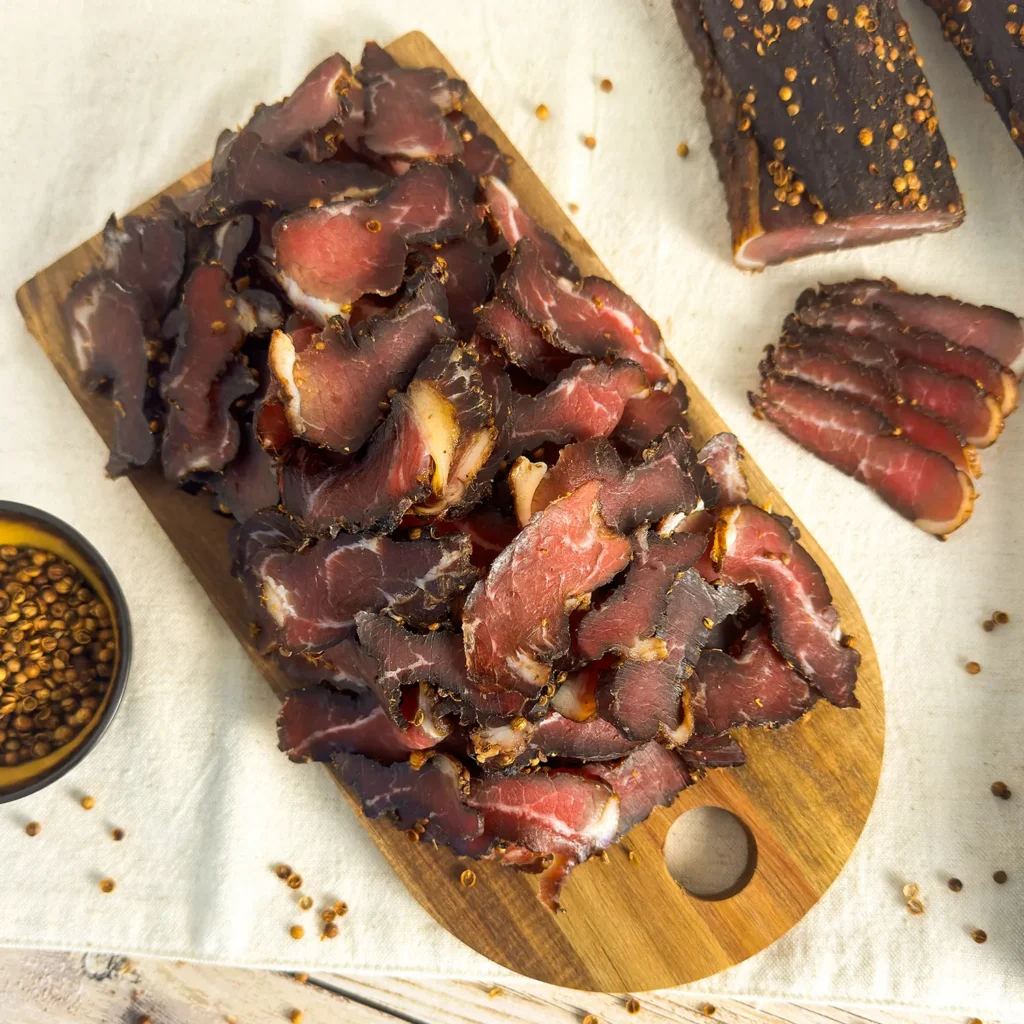 a grade beef biltong pile sliced on a wood board main image