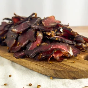 a grade beef biltong pile sliced on a wood board angle view image