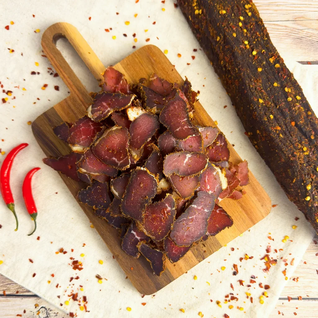 chilli biltong on a wood cutting board , sliced and whole main image