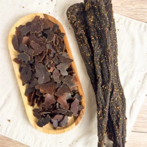 Kudu biltong sliced and whole on a wood cutting board main image