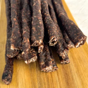 beef droewors pieces on a wood cutting board close view of droewors