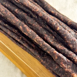 beef droewors pieces on a wood cutting board angle view image