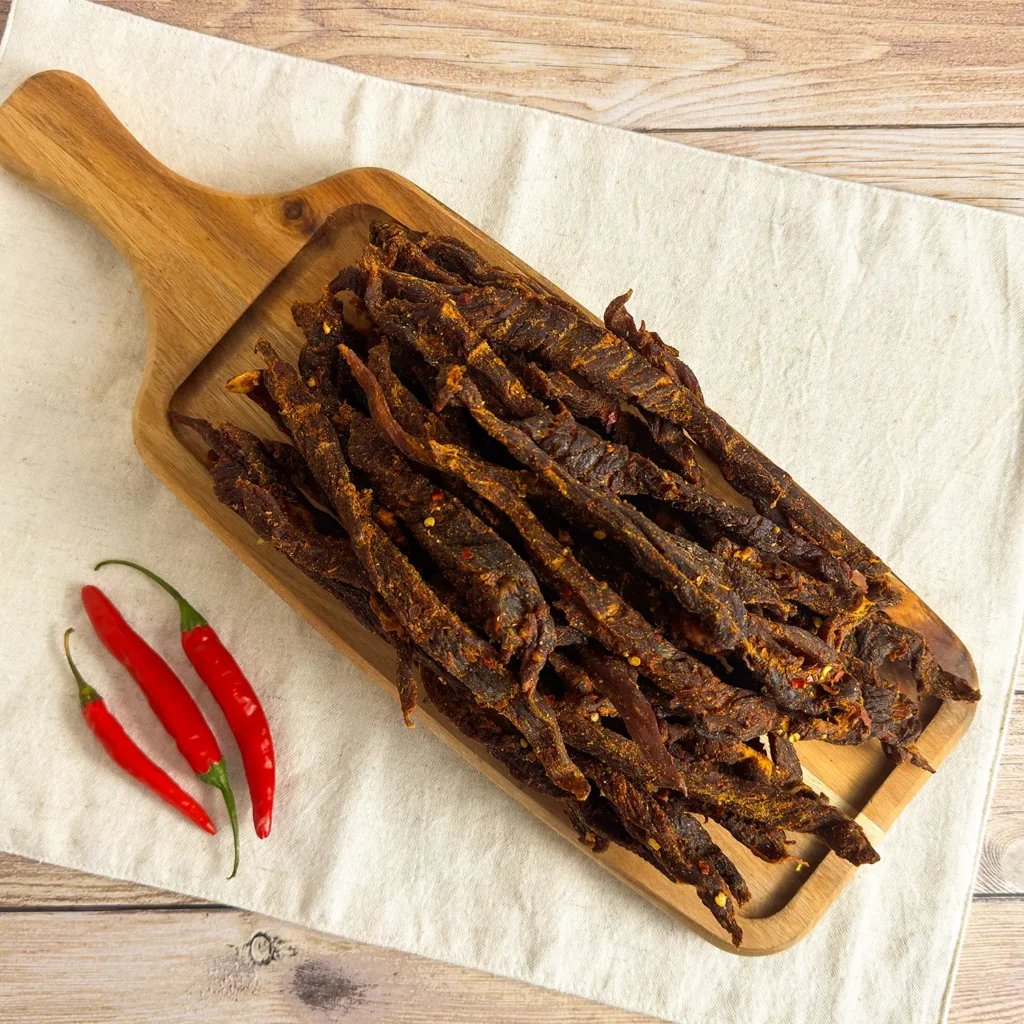 chilli sticks or chilli bites , pile of chilli sticks on a wood cutting board main image
