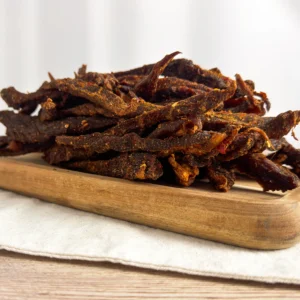 chilli sticks or chilli bites , pile of chilli sticks on a wood cutting board side view of chilli sticks