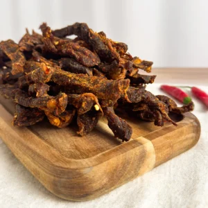 chilli sticks or chilli bites , pile of chilli sticks on a wood cutting board angle view of chilli sticks