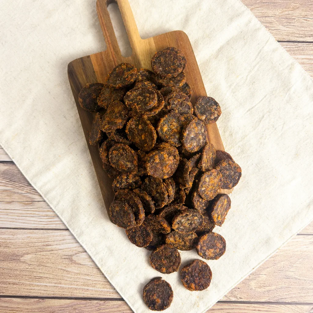 chutney biltong wheels small on a wood cutting board showing a pile of biltong wheels main image