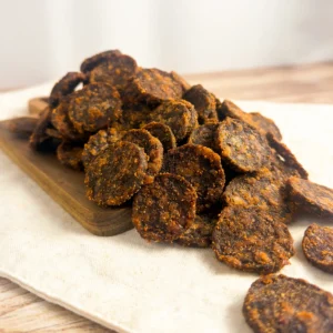 chutney biltong wheels small on a wood cutting board showing a pile of biltong wheels angle view of biltong wheels
