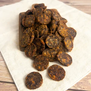 chutney biltong wheels small on a wood cutting board showing a pile of biltong wheels top view of the biltong wheels